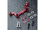 MST red anodized aluminium steering joint plate with included bearings, spacers, and screws on a dark textured surface.