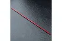 A red anodized aluminium centre driveshaft for an RC car, shown against a dark textured background.