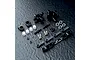 A set of MST black aluminium rear hubs and associated hardware including ball ends, turnbuckles, and spacers on a textured black surface.