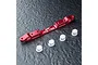 A red anodized aluminium MST adjustable lower suspension arm mount with four small white plastic bushings on a textured black surface.