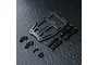 MST carbon fiber front suspension arm mount set including a carbon plate, two metal blocks, two posts, and various black screws on a dark textured surface.