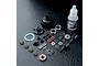 An MST 60T limited slip differential kit including gears, housing, bearings, screws, shims, and a bottle of 3000# gear diff oil on a black surface.