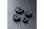 A set of four grey plastic RC drive gears of varying sizes arranged on a dark textured surface.
