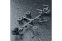 A black plastic parts tree containing RC car wheel hexes, steering hubs, and washers on a textured dark surface.