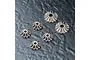 A set of six metal differential bevel gears of varying sizes arranged on a dark textured surface.