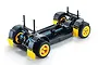 A 1/10 scale RC rally car chassis roller with yellow wheels, black mudflaps, and blue shock absorbers on a white background.