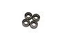 Four small metal shielded ball bearings grouped together on a plain white studio background.