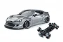 Studio shot of a metal grey 86RB RC drift car body and its matching black chassis on a white background.