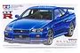 Tamiya 1/24 scale Nissan Skyline R34 GT-R V-spec plastic model kit box art showing a blue sports car.