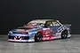 Pandora RC HCR32 Skyline 4Dr BN-Sports drift body shell painted blue and red with extensive sponsor decals.
