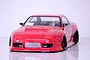 Front view of a red RC drift car body shell on a white studio surface with a visible intercooler and black wheels.