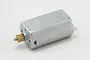 A studio product shot of a small brushed RC electric motor with a pre-installed brass pinion gear.