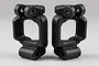 Two black plastic RC car C-hub carriers displayed side by side against a clean light grey studio background.