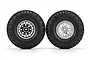 Two 1/10 scale RC crawler tyres mounted on silver beadlock wheels against a white background.