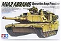 Tamiya 1/35 scale M1A2 Abrams tank plastic model kit box art showing a tan tank with crew figures in a desert environment.