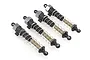 A set of four assembled RC shock absorbers with black plastic bodies, silver metal springs, and translucent shafts against a white background.