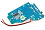 A blue printed circuit board (PCB) for an RC transmitter with a green button, soldered wires, and various electronic components.