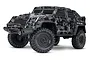 Traxxas TRX-4 Tactical Unit RC rock crawler featuring a black and grey camouflage body, rugged off-road tires, and a front bumper with a winch.