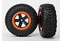 Two Traxxas RC short course wheels with black rubber tyres and black and orange rims against a white background.
