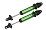 Two green anodized aluminium GTX shock absorbers for Traxxas X-Maxx RC truck, shown without springs against a plain white background.