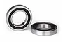 Two rubber-shielded ball bearings for RC vehicles, one standing upright and one lying flat on a white background.