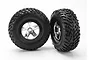 Two Traxxas 2.2/3.0 inch off-road tires pre-mounted on satin chrome and black wheels against a white background.