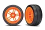 Two Traxxas 1.9 inch Response slick tires pre-glued onto bright orange split-spoke wheels, shown from front and angled views.