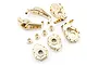 A set of brass RC upgrade parts for the Traxxas TRX-4, including steering knuckles, portal covers, and wheel hexes on a white background.