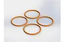 Four orange rubber O-rings arranged in a diamond pattern on a plain white background.