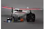 HobbyZone Super Cub S 1.2m RC trainer plane with Spektrum DXe transmitter, battery, charger, and accessories on a grey background.