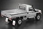 A silver 1/10 scale RC Toyota Land Cruiser pickup truck body shell featuring a detailed truck bed with movable sides and Toyota branding on the mudflaps.