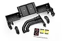 Traxxas UDR black plastic chassis tray, driveshaft clamps, and fuel filler neck components with a small decal sheet on a white background.