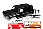 A black Traxxas TRX-4 Ford Bronco RC body shell with chrome bumpers, accessories, and decal sheets on a white background.