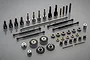 A collection of Tamiya RC driveline parts including metal gears, drive shafts, bearings, and bushings arranged on a grey surface.