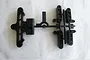 A black plastic parts tree containing suspension arm and bumper mount components for a Tamiya RC model.