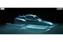 A clear, unpainted 1/10 scale Tamiya Hornet RC car body shell and rear wing set against a dark background.