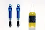 Two blue aluminium RC shock absorbers and a small bottle of Tamiya damper oil on a white background.
