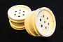 Two white Tamiya RC buggy rear rims with a multi-hole design on a dark background.