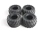 Four black rubber RC monster truck tyres with a V-groove tread pattern arranged in a square formation on a white background.