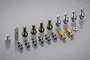 A collection of various metal suspension pivot balls, ball studs, and small hardware components for Tamiya RC cars arranged on a grey surface.