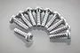A collection of ten Tamiya 3x10mm coarse thread binder head screws arranged in a semi-circle on a reflective grey surface.