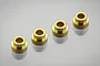 Four small brass shaft guides or bushings arranged in a diagonal line on a white reflective surface.