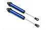 Two blue anodized aluminium GTR shock absorbers for Traxxas UDR RC cars, shown against a plain white background.