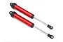 Two red anodized aluminium GTR shock absorbers for Traxxas UDR RC car, shown against a white background.