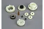 A collection of various plastic and metal gears and bushings for the Traxxas EZ-Start 2 system laid out on a grey surface.