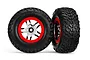 Two Traxxas 2.2/3.0 inch off-road tires pre-mounted on satin chrome and red wheels against a white background.