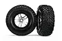 Two Traxxas 2.2/3.0 inch off-road tires pre-mounted on satin chrome and black wheels against a white background.