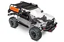 Traxxas TRX-4 Sport RC rock crawler kit with a clear, unpainted polycarbonate body shell, black roof rack, and orange recovery boards.
