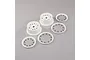 Two white RC car wheel rims and three white beadlock rings with black screws arranged on a grey background.