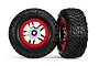 Two Traxxas 2.2/3.0 inch off-road RC tires pre-mounted on satin chrome and red beadlock-style wheels against a white background.